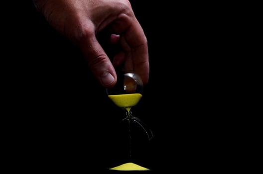 Broken hourglass on black background photo