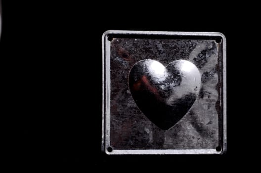 Silver heart shape on black background photo