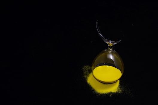 Broken hourglass on dark background photo