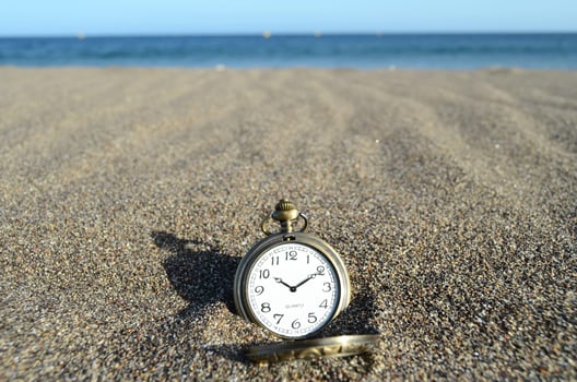 Pocket watch in the sand photo