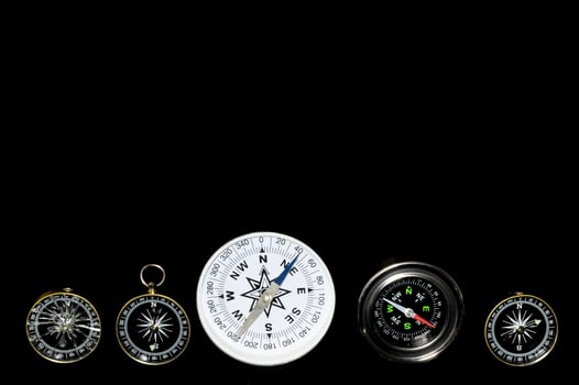Analog compasses on black background photo
