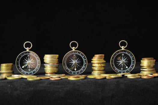 Compass and coins on black background photo