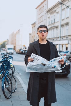 Smart man in sunglasses with paper on street photo