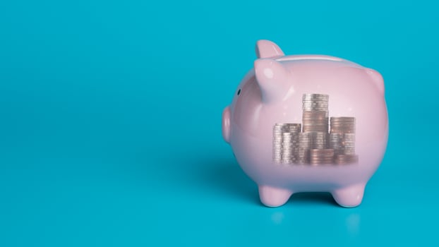 Piggy bank placed on blue background, financial and investment concept from saving money and business profitable income planning, retirement savings. photo