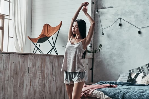 What a great morning Attractive young woman stretching and smiling while standing in the bedroom at home photo