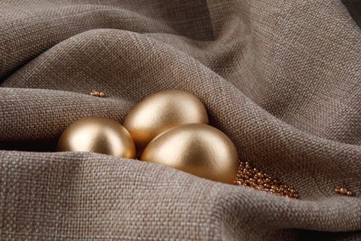 Three golden eggs are wrapped in cloth. photo