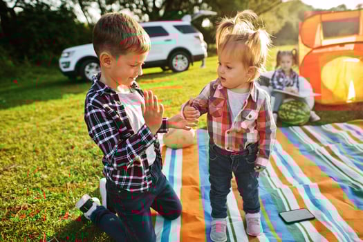 Kids spending time together. Outdoor picnic blanket. Brother and sister love. photo