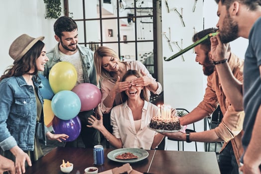 Time to make a wish. Group of happy people celebrating birthday among friends and smiling while having a dinner party photo