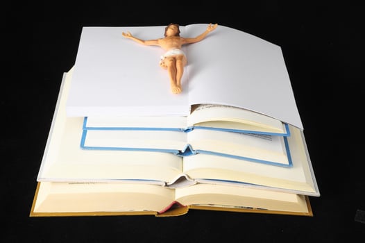 Small Jesus Christ figure on open books photo