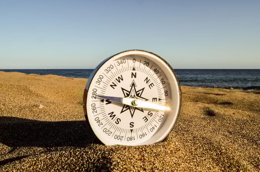 Compass on the ground by the ocean photo