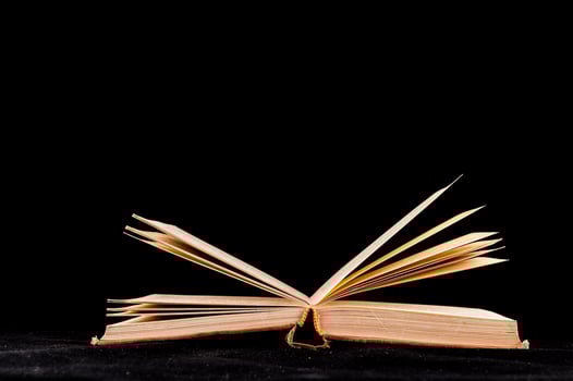 Opened book isolated on black background photo