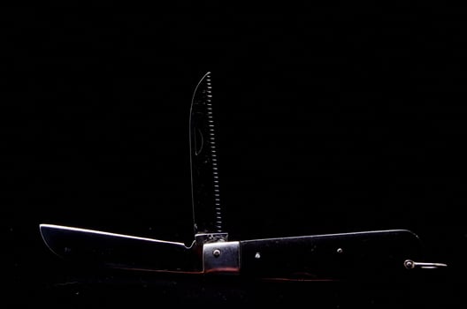 Multifunctional knife on black background photo