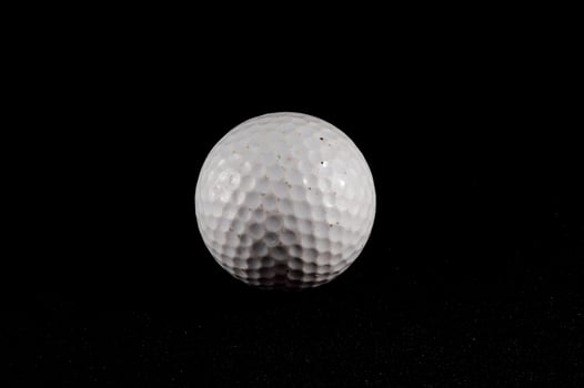 A golf ball on black background photo