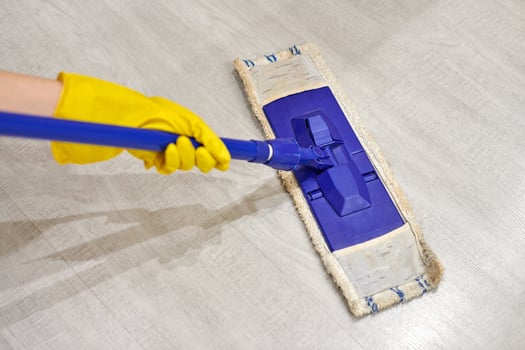 Girl in protective gloves cleaning floor using flat wet mop. photo