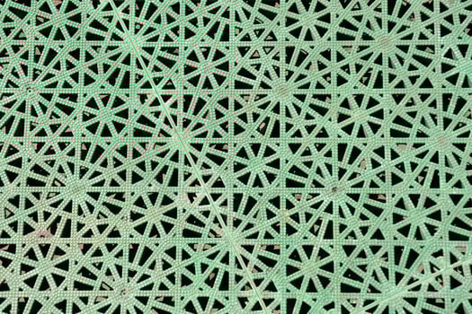 a green metal mesh with holes in it photo