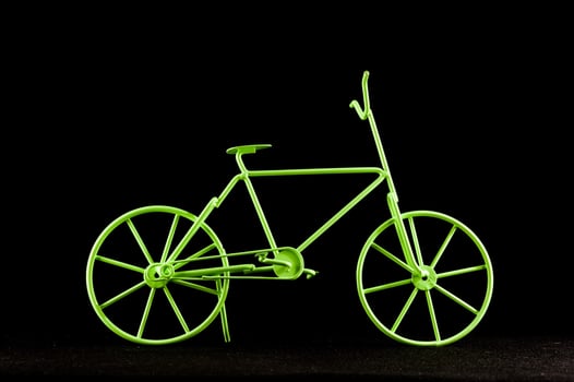 a green bicycle is shown against a black background photo