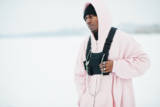 Stylish urban style african american man in pink hoodie posed at frozen lake in winter. photo