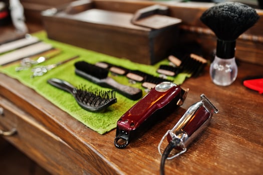 Barber tools on wooden background table with electric machines. photo