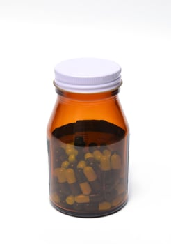 group of green capsule medicine in bottle photo