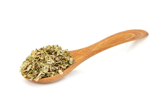 Oregano in wooden spoon  isolated on white background photo