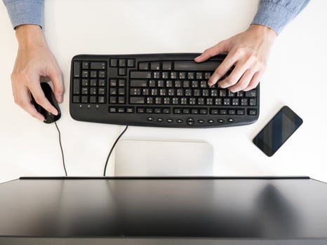 Top view of male hands working on computer on the desk. photo