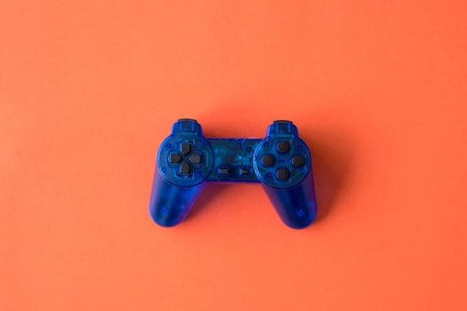 Video game controller on orange background. photo