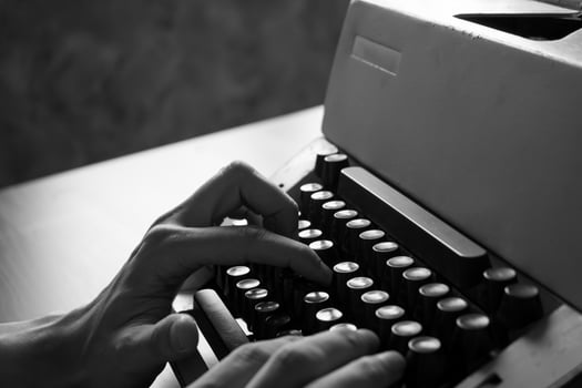 Close up of Male hands typing on the old typewriter. Black and White tone photo