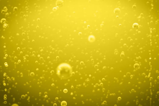 Defocus blurred transparent yellow colored clear calm water surface texture with splashes and bubbles. Pouring beer with bubble froth in glass for background on side wave curve shape texture foam. photo