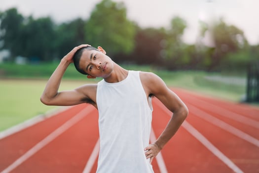 Athletes sport man runner wearing white sportswear to stretching and warm up before practicing on a running track at a stadium. Runner sport concept. photo