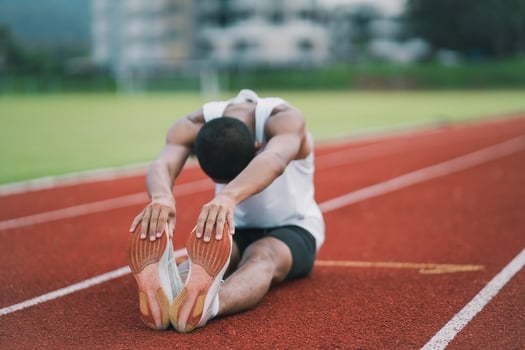 Athletes sport man runner wearing white sportswear to stretching and warm up before practicing on a running track at a stadium. Runner sport concept. photo