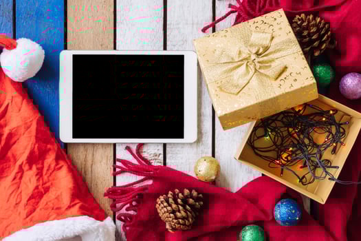 Top view of Tablet and christmas decoration on wooden table. photo