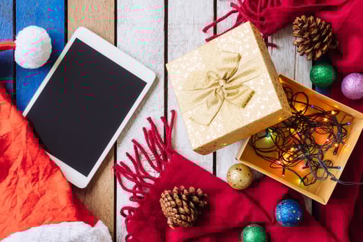 Top view of Tablet and christmas decoration on wooden table. photo