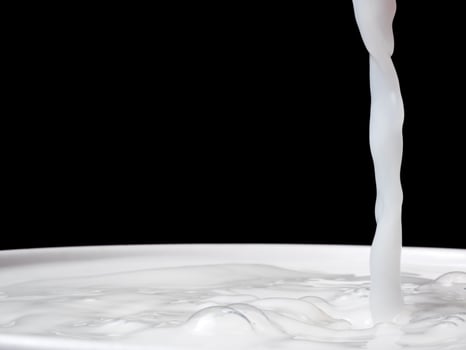 Splash of milk from a cup on black background. photo