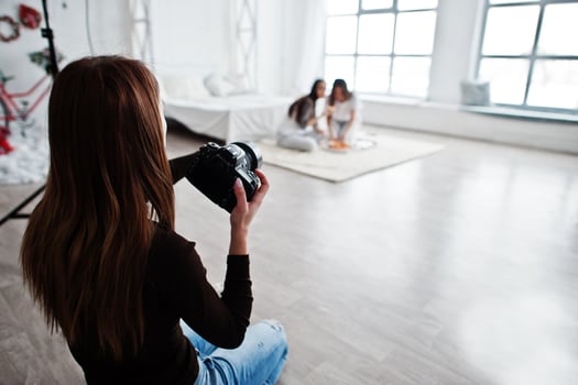 Close up back of young girl photographer shooting on studio two girls. Professional photographer on work. photo