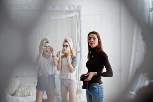 Young girl photographer shooting on studio two girls while they make their own masks cream . Professional photographer on work. photo