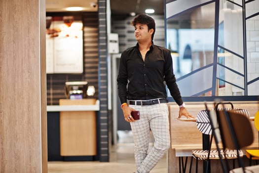 Stylish indian man posed at fast food cafe with mobile phone at hand. photo