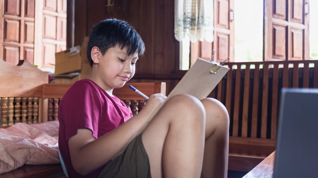 Asian boys enjoy free time practicing pencil drawing at home during school holidays. Kid Creators concept photo