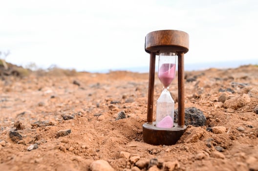 an hourglass sitting on the ground in a desert photo