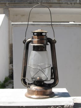 an old fashioned oil lantern sitting on a ledge photo