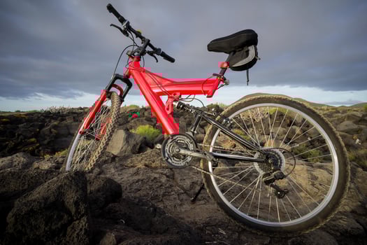 a red bike is parked on a rocky hill photo