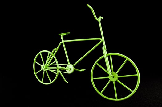 a green bicycle is shown against a black background photo
