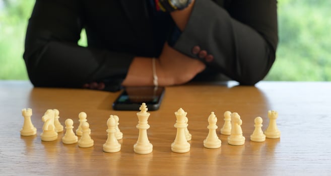 Businessman hands in black suite sitting and pointing chess king on vintage table meaning of planning and strategy. Decision and achievement goal concept. photo