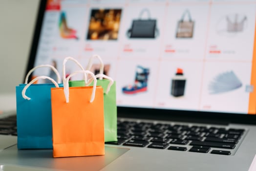 Online shopping or ecommmerce delivery service concept,Paper shopping bag on a laptop computer ,Easy shopping online concept photo