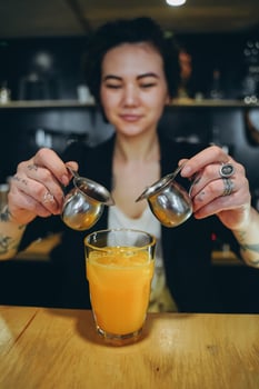 KIEV, UKRAINE - APRIL 14, 2019 A girl makes a orange coffee cocktail photo
