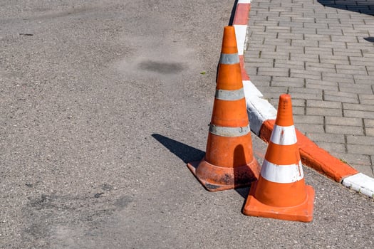White orange traffic hazard cone on asphalt road repair photo
