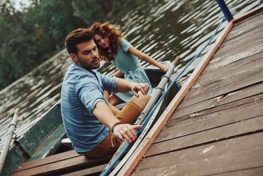Beginning romantic travel. Beautiful young couple getting ready to row a boat while enjoying their date outdoors photo