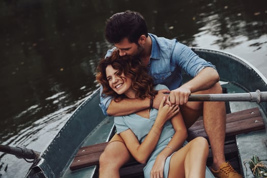 Made to love each other. Beautiful young couple embracing and smiling while enjoying romantic date on the lake photo