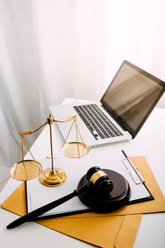 Business and lawyers discussing contract papers with brass scale on desk in office. Law, legal services, advice, justice and law concept picture with film grain effect photo