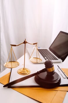 Justice and law concept.Male judge in a courtroom with the gavel, working with, computer and docking keyboard, eyeglasses, on table in morning light photo