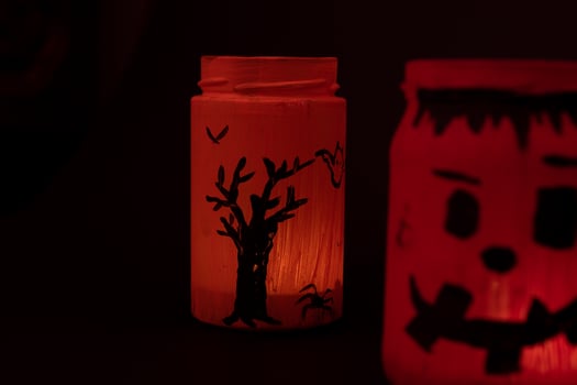 Hand painted jar for Halloween, jar of orange color on a black background. photo